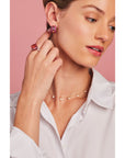 model wearing Ouro Pink Sapphire Hoop Earrings along with other staple pieces in Graziela's jewelry collection