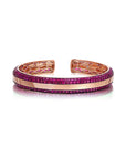 Three-sided pink sapphire bangle with a golden band and pink sapphires set in vivid cranberry rhodium